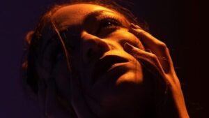 woman holds face with both hands